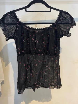 Svart blus med blommigt mönster - Svart blus topp med rosa blommor från Gina Tricot, storlek M.