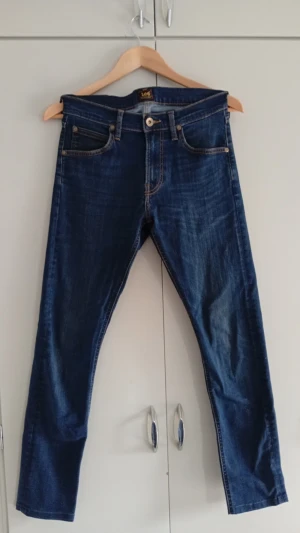 Lee Jeans - Säljer ett par mörkblå Lee-jeans i mycket bra skick. Klassisk och stilren design som passar till allt. Bekväm passform i storlek W28/L32. Säljs eftersom de inte används.
