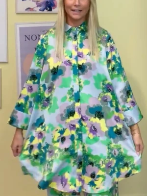 Blommigt loungewear-set i pastell - Säljer ett oversized loungewear-set från YAS med skjorta och byxa i glansigt tungt lyxigt material. Setet har ett färgstarkt blommönster i grönt, lila, gult och blått på ljus bakgrund. Skjortan har krage och knappar framtill, vida ärmar och lös passform. Perfekt för chill dagar hemma eller casual kontorsoutfit.