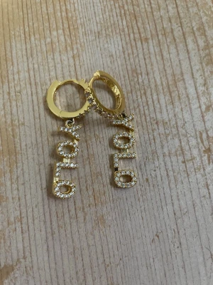 Guld örhängen🫰🏼 - Yolo örhängen från Lyla med strass och är andvända några få gånger💞rengör örhängena innan jag skickar dom💞🫰🏼