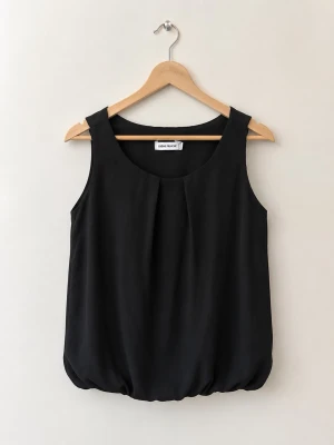 Svart ärmlös topp från Creme Fraiche - Stilren svart ärmlös topp från Creme Fraiche med rund halsringning och lätt puffad nederkant. Perfekt att matcha med jeans eller kjol för en snygg look. Enkel och tidlös design som passar till många outfits.