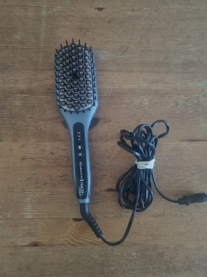 Remington Keratin Protect värmeborste - Elektrisk värmeborste från Remington Keratin Protect-serien. Borsten är grå och svart med keramisk beläggning och har tre värmeinställningar (150°C, 190°C, 230°C). Perfekt för att styla och släta ut håret snabbt och enkelt. Sladd medföljer.