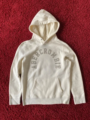 Abercrombie and Fitch hoodie - Abercrombie and fitch hoodie i storlek XS, den passar dock större. Jag på bilden är 180 cm. Mått: axelbredd - 44cm, längd - 63cm. Skriv för fler bilder och frågor!