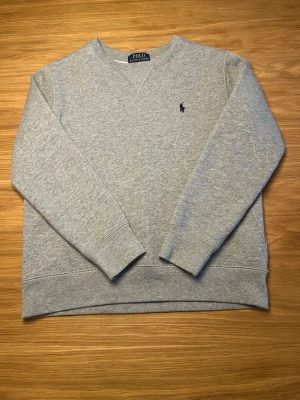 Grå sweatshirt från Polo Ralph Lauren - Polo tröja i väldigt bra skick. Köpt på NK. Storlek medium i barnstorlek,10-12 år