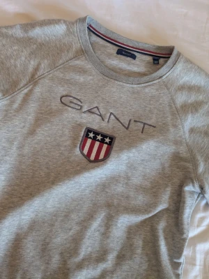 Grå sweatshirt från GANT - Snygg grå sweatshirt från GANT med broderad logga, endast använd ett fåtal gånger så ser ut som nyskick