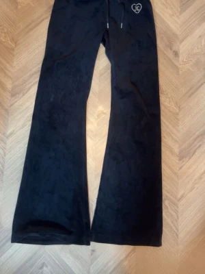 Svarta Juicy Couture  - Svarta byxor Juicy Couture med JC logga på framsidan och Juicy logga på baksidan 