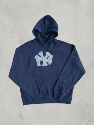 Hoodie Hand-Made | Marinblå - Tjena, jag säljer denna riktigt feta hoodie jag gjort själv med New York Yankees tryck. Original hoodien är från Lager 157 i modellen ”Luka” (Sista bilden)  Riktigt snygg passform   Storlek M  Marinblå  100%bomull   Mått 📏  Längd 69cm Axelbredd 66cm  Axel till ärmslut 60cm  Hör av dig om du undrar något så löser vi det! 