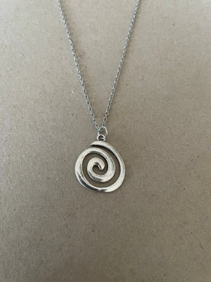 Halsband spiral - Min dotter och ja pysslar/ gör smycken som hobby.   Kedja 50cm rostfritt stål  Berlock : zinklegering  Bud accepteras inte