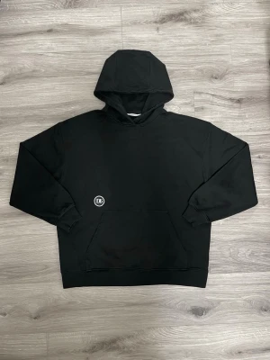 Db (Douchebags) Ænywear Hoodie - Svart - Stl L - Säljer min Db Ænywear Hoodie i färgen svart. En extremt bekväm och stilren hoodie i hög kvalitet från skandinaviska märket Db (f.d. Douchebags).  Storlek: L (Något oversized/boxig passform, så den sitter väldigt skönt). Skick: Mycket gott skick. Rök- och djurfritt hem. Material: 100% bomull. Detaljer: Designad i Skandinavien, rejäl huva och mjuk insida. Skickas snabbt och välpaketerad!