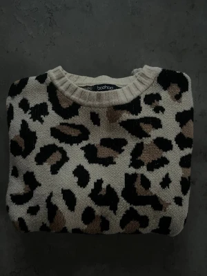 Leopardmönstrad stickad tröja  - Stickad tröja från Boohoo med leopardmönster i beige, svart och brunt. Den har inga defekter och känns som ny. Storlek S/M men skulle säga att den sitter mer som en S 