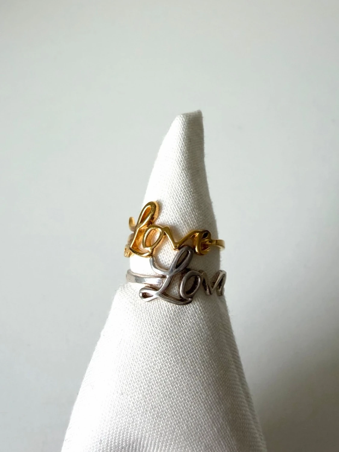 Två ringar med Love-text i guld och silver