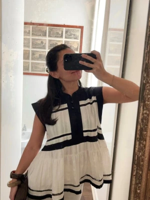Vit och svart blus från Isabel Marant Étoile  - Supersöt blus från Isabel Marant i vitt med svarta ränder och detaljer. Blusen har en lös passform, är ärmlös och har en volangig nederdel. Passar 34-38