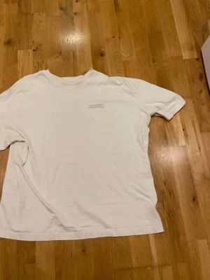 Zara Vit oversized t-shirt med tryck stl XL - Vit oversized t-shirt med rund halsringning och ett litet tryck med text på bröstet. Enkel och stilren design som passar till det mesta. Tillverkad i mjukt bomullstyg för en skön känsla.