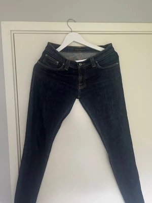 Mörkblå skinny jeans från Nudie - Säljer ett par mörkblå skinny jeans från Nudie som är i storlek 30/32 i ett gott skick.