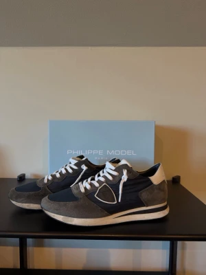 Philippe model skor  - Säljer mina Philippe model trainers då jag inte använder dem längre. De är i bra skick. Storlek 43. Tillkommer även ett extra skosnöre i mörkblå som kan ses på en av bilderna. 