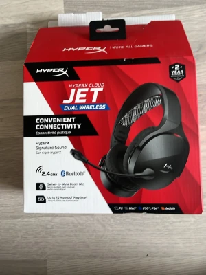 HyperX Cloud Jet Dual Wireless headset - HyperX Cloud Jet Dual Wireless headset med svart design och mjuka öronkuddar. Trådlös anslutning via 2.4GHz och Bluetooth, avtagbar mikrofon och justerbart huvudband med mesh-detaljer. Perfekt för gaming på PC, Mac, PS5/PS4 och mobil. Inkluderar USB-dongel och laddkabel. Paketet är sönder vid sidan men går att tejpa den