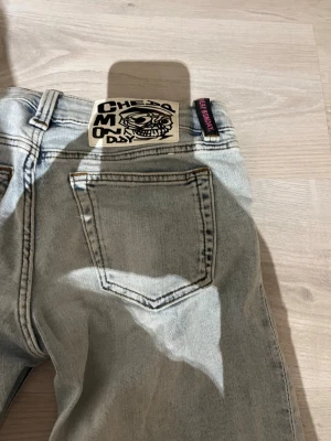 Ljusblåa Cheap Monday jeans - Säljer ett par ljusblåa jeans från weekday. döskalle bak på linningen. Jeansen har raka ben och är tillverkade i denim. Perfekta för en avslappnad och trendig stil. Aldrig använda då den är för små tyvärr 