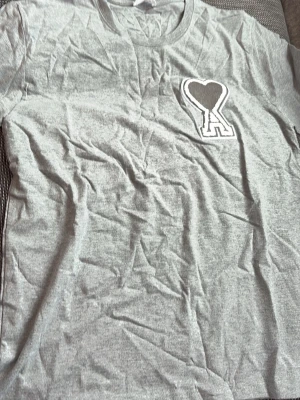 Grå t-shirt från Ami med hjärtdetalj - Ami sett med t shirt och shorts. De kostar 399 styck och 700 för båda. Skriv om ni har frågor och funderingar  