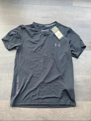 Svart träningströja från Under Armour - Svart kortärmad träningströja från Under Armour, skön passform och kan användas vid olika tillfällen