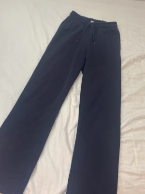 Mörkblå mjukisbyxor Gina Tricot - Mörkblå mjukisbyxor från Gina Tricot, basically basics-kollektionen. Byxorna har raka ben, resår i midjan och dragsko för skön passform. Perfekta för chill dagar eller när du vill vara extra bekväm.