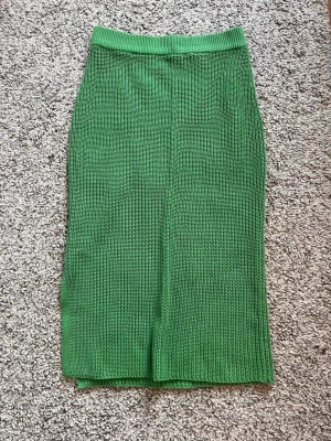 Grön stickad kjol från Rainbow - Säljer en grön stickad kjol från Rainbow. Kjolen har en rak, enkel design med resår i midjan och är i en snygg, klar grön färg. Perfekt att styla med en crop top eller oversized tröja för en trendig look.