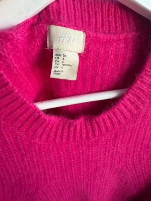 Rosa stickad tröja från H&M - En jätte fin stickad tröja från H&M. Tröjan har rund halsringning, långa ärmar och ribbstickad vid kragen samt längt ner på ärmarna. Perfekt för att liva upp garderoben med en färgklick.🩷