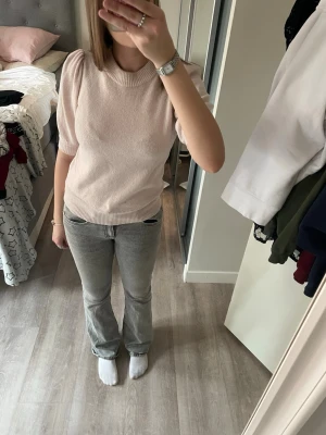 Ljusrosa stickad topp Vero Moda - Supersöt ljusrosa stickad topp från Vero Moda med puffärmar och ribbade muddar. Tröjan har en högre rund halsringning och är gjord i mjukt material som känns skönt mot huden. Perfekt för dig som gillar en feminin och trendig stil. pris går att diskutera
