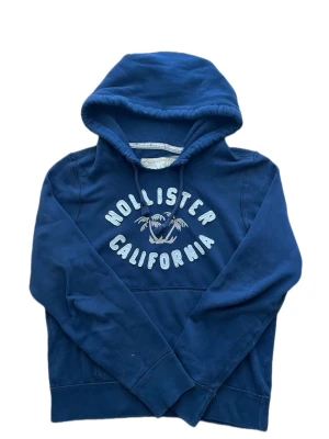Hollister vintage hoodie M - Säljer en riktigt mörkblå vintage hollister hoodie med broderad text. Tröjan är i storlek M. Tröjan har inga defekter - inga fläckar - inga hål - ingen dålig lukt ( kommer från djur och rökfritt hem🚭🐾) Tröjan är nyskick, då den knappt är använd✨🌟  Gåvor medföljer vid köp utan bud🎁💝  Tveka inte att ställa frågor vid minsta funderingar💬