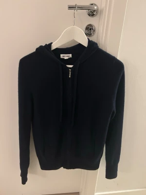 Mörkblå hoodie från Soft Goat - Mörkblå hoodie från Soft Goat i 100% kashmir. Tröjan är i stl M i dam och är i bra skick.