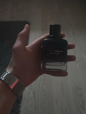 Givenchy Gentleman edt intense full - Givenchy Gentleman parfym i en stilren, mörk glasflaska med svart kork. Flaskan har en elegant och maskulin design med märkets logga i vitt framtill. Perfekt för dig som gillar exklusiva dofter och snygg förpackning.