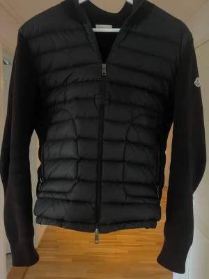 Moncler Cardigan - Säljer en Moncler Cardigan i storlek M. Efter ett tag så passade den inte längre så det är därför jag säljer den. Väldigt bra skick och trendig jacka. Klockrent plagg. Passar till nästan alla outfits! Finns ej luva, endast seriösa köpare!