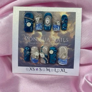 BlueMyth(S);Medium Square;Curved - Unika handgjorda press-on naglar i blått, silver och nude. Naglarna har coola havsinspirerade detaljer, silverkedjor, snäckskal och pärlor. Mix av glansiga och matta ytor med handmålade mönster och 3D-dekorationer. Perfekt för dig som vill sticka ut.S: 15 mm, 11,5 mm, 12 mm, 11 mm, 9 mm 