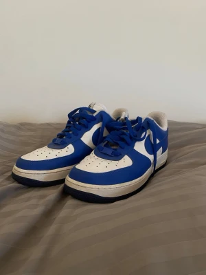 Blå-vita Nike Air Force One - Säljer ett par riktigt clean AF1 i snygg blå färg.   Använda men i bra skick – inga större defekter, bara lite normalt slitage (se bilder). Storlek: 41   Nypris: ca 1200 kr Perfekta till sommaren / vardag Säljs pga används inte längre. Pris: 500 kr (kan diskuteras vid snabb affär)