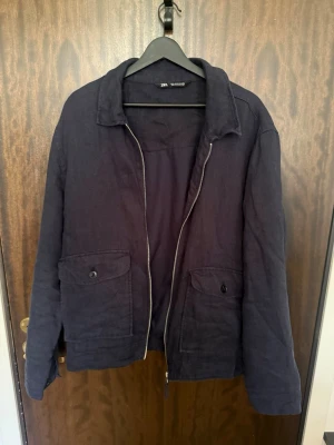 Mörkblå overshirt från Zara - Stilren mörkblå overshirt från Zara med dragkedja framtill och två stora fickor med knappar. Overshirten är i storlek XL men passformen är snarare Large eller en stor Medium. Tveka inte att skriva för fler bilder eller om du undrar något//Felkannn
