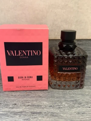 Valentino Donna Born In Roma Intense - Valentino Donna Born In Roma Intense EdP i en lyxig glasflaska med nitar och svart lock. Flaskan har en gradient från mörkbrun till klar och rymmer 100 ml. Kommer med en rosa kartong med svarta detaljer. En elegant och modern parfym för dig som gillar exklusiva dofter.
