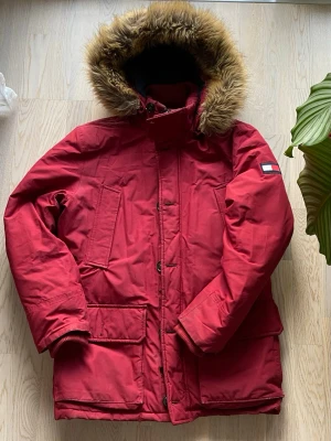 Parkajacka Tommy Hilfiger - En parkajacka från Tommy Hilfiger, användes för flera år sedan ett litet tag men passar inte längre helt. Den är varm och lång för kall vintrar. Små synliga delar av användning, ett litet hål i innerfickan som går att laga, ett litet lagat hål vid sidan av en ficka (se bild 6). Men inget som syns eller påverkar funktion. 