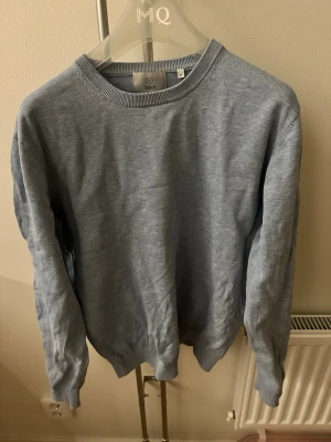 Ljusblå stickad tröja Bläck - Snygg ljusblå tröja från Bläck i storlek M. Tröjan har rund halsringning och ribbade muddar vid ärmslut och nederkant. Perfekt för lager på lager och enkel att matcha med olika stilar.