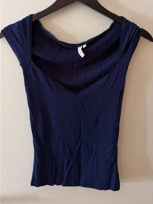 Nelly topp - Marinblå urringad topp med detaljer från Nelly i strl XXS. 