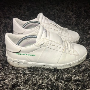 Vita sneakers från Valentino - Skorna har en stilren design med snörning och en prickig sula. Perfekta för en trendig look. Det är en limited edition sko som är mer miljövänlig och heter då "OPEN FOR A CHANGE". Äkta såklart. Har en skada på höger sida av vänster sko. Skadan märks inte av när man har på sig dom. Mycket bra skick bortsett från skadan. Box och dustbags samt annat ingår. Pris kan diskuteras. Vid frågor eller intresse tveka inte att höra av dig. Mvh Jolle closet