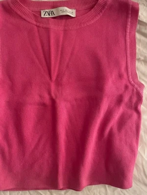 Rosa ribbad linnetopp från Zara - Säljer en snygg rosa ribbad linnetopp från Zara. Toppen är ärmlös och har en rund halsringning. Perfekt att styla med jeans eller kjol för en trendig look.