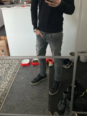 Grå Dondup George  - Säljer ett par gråa dondups i modellen George! Grå tvätt med slitningar vilket är väldigt eftertraktat. Bara att höra av er om ni har frågor eller funderingar!