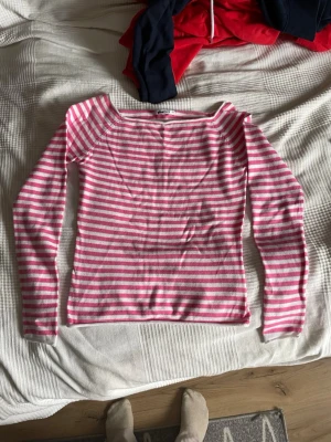 Rosa och vit randig topp Gina Tricot - Säljer en långärmad topp från Gina Tricot i storlek XS. Toppen har ett randigt mönster i rosa och vitt, rund halsringning och är gjord i mjuk bomull. Perfekt för dig som gillar en enkel men färgglad stil.