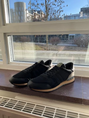 Svarta Valentino sneakers i mesh och läder - Hej! Säljer nu dessa väldigt snygga Valentino Rockrunner sneakers   Storlek: 44 Färg: Svarta, gråa och vinröda Skick: Väldigt fint skick   Skickas spårbart eller hämtas upp efter överenskommelse. Vid intresse – hör gärna av dig.