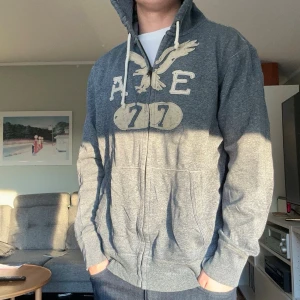 American Eagle vintage hoodie zip - En riktigt cool zip up hoodie från American Eagle😮‍💨 Sitter stort på mig då storleken är Xl men passar lite mer som L skulle jag säga. Modellen är 176cm lång. Tunnare tyg med en bra dragkedja och skicket är bra 👍 Ställ gärna frågor! Mvh