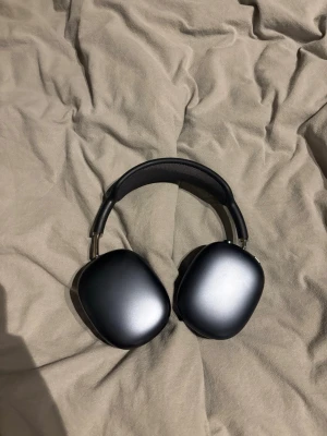 Apple AirPods Max  - Snygga svarta Apple AirPods Max med en stilren design i aluminium och mjuka öronkuddar i mesh-tyg. Hörlurarna har en bred, vadderad bygel och stora, ovala kåpor som ger grym komfort och ljudupplevelse. Perfekta för dig som vill ha premiumkänsla och modern teknik. Köpte dom för två månader sen har typ knappt använt dom och ligger typ bara hemma därför säljer jag dom.