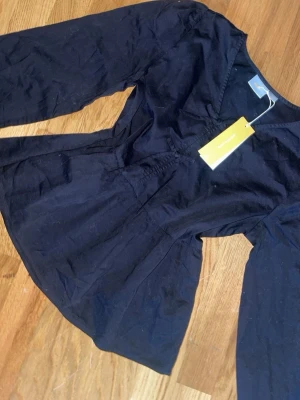 Svart blus med v-ringning - från Gina oanvänd 