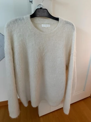 Vit mohair  tröja från NA-KD - Mysig vit stickad tröja från NA-KD med rund halsringning och lång ärm. Tröjan har en fluffig och mjuk känsla, perfekt för lager-på-lager och chill dagar. Enkel och stilren design som passar till det mesta.