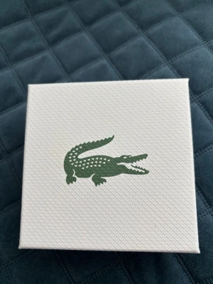 Lacoste armband i silver - Säljer en snygg original armband från Lacoste. Armbandet är aldrig använt då den inte passar mig. Priset kan diskuteras vid snabb affär.