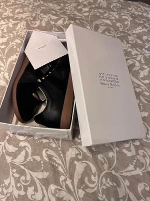 Maison Margiela svarta sneakers - Maison Margiela sneakers i svart läder och mocka. Storlek 44