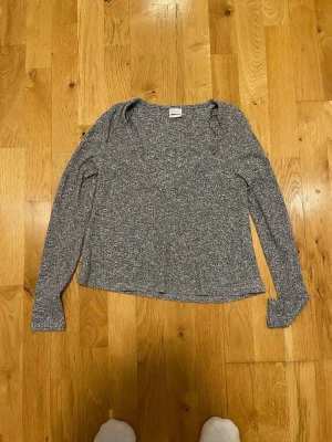 Gråmelerad långärmad tröja Gina Tricot stl S  - Mysig gråmelerad långärmad tröja från Gina Tricot. Tröjan har en rund halsringning och är tillverkad i ett mjukt, stretchigt material som passar perfekt till alla tillfällen. Enkel och stilren design som är lätt att matcha med olika outfits.